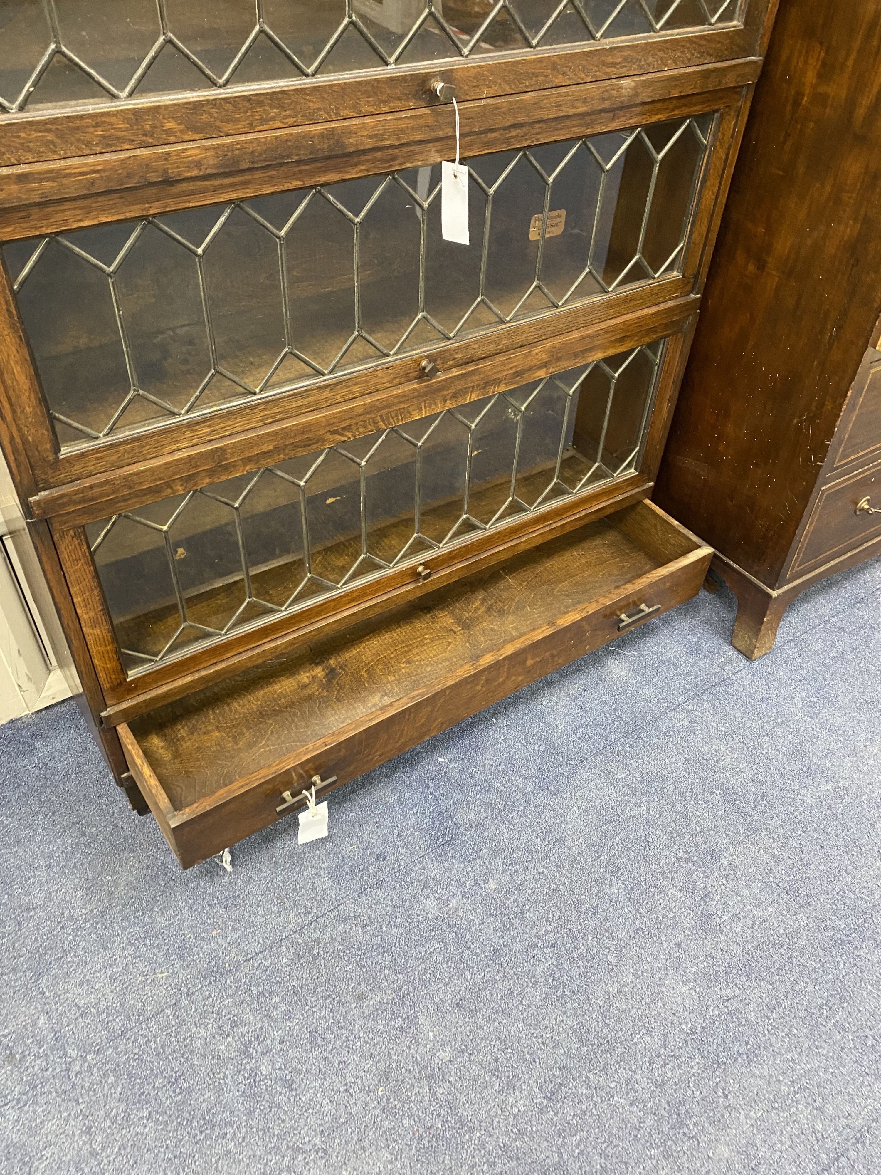 A Globe Wernicke oak three section leaded bookcase, length 85cm, depth 24cm, height 110cm